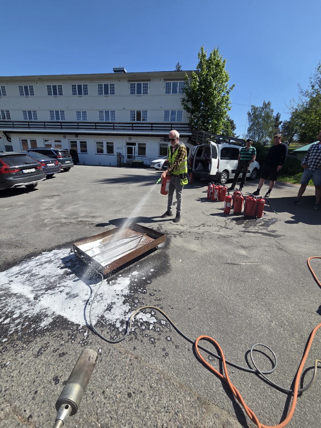 Deltaker bruker brannslukningsapparat under øvelse hos bedrift